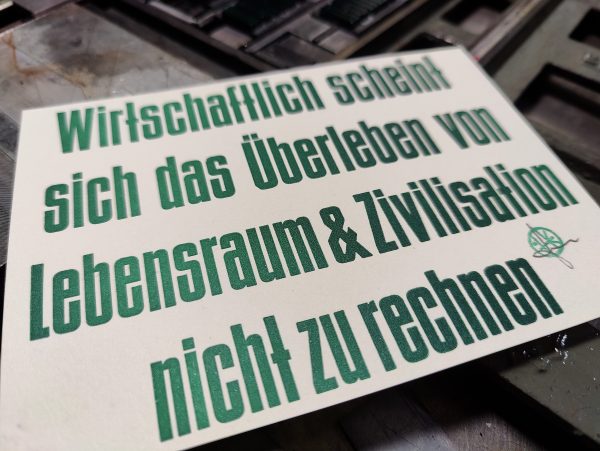 Foto eines Musterdrucks. Der Text lautet: Wirtschaftlich scheint sich das Überleben von Lebensraum & Zivilisation nicht zu rechnen.