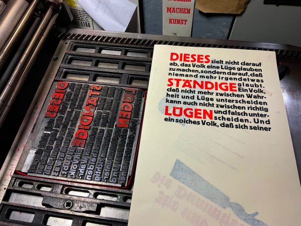 Foto eines zweifarbigen Musterabzuges neben der zweifarbig eingefärbten Bleisatzform.