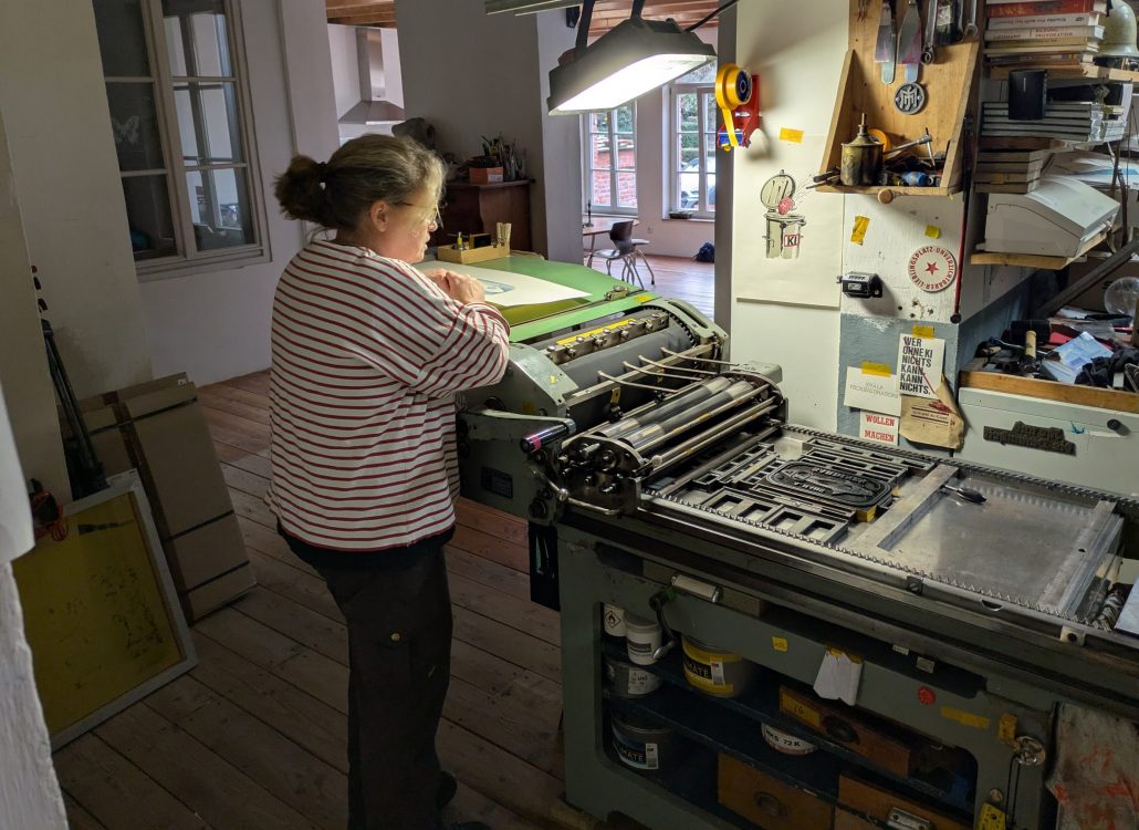 Foto einer Frau an einer Korrex Hannover Druckmaschine