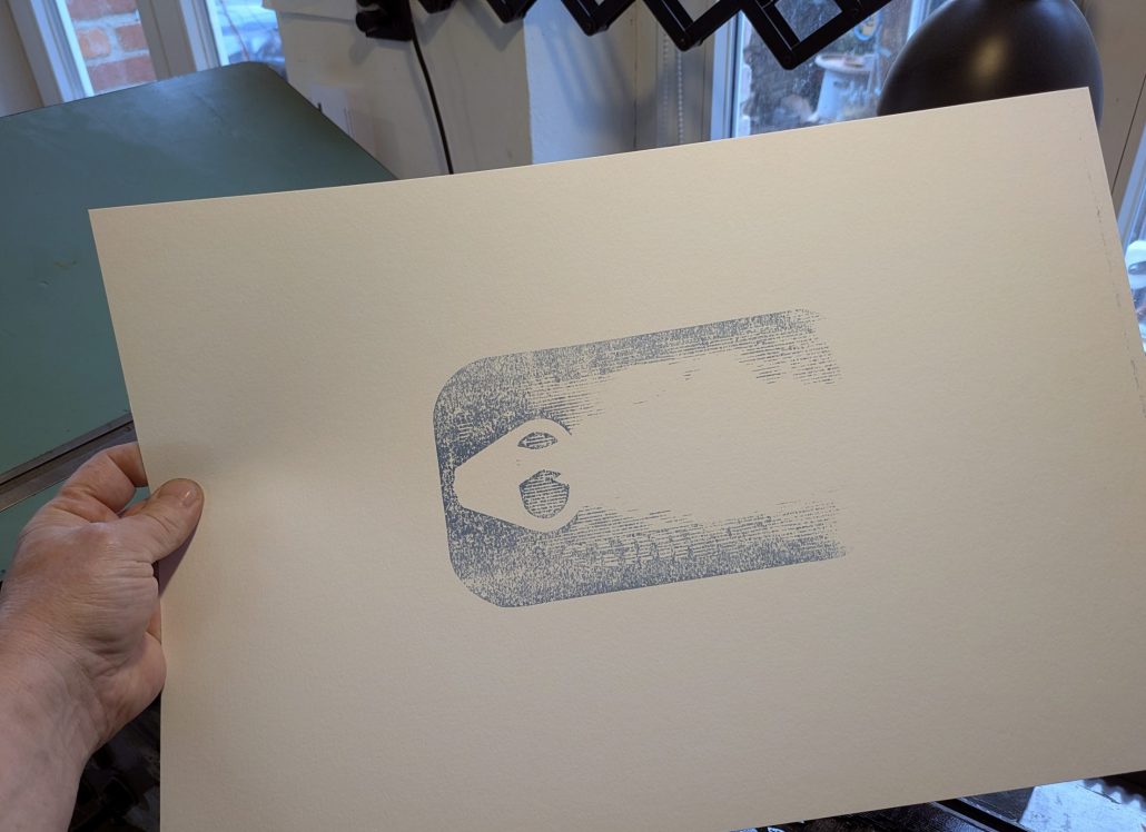 Foto meiner Hand, die die den Blau-Abzug in der Hand hält, auf dem man vom späteren zweifarbigen Motiv noch wenig erahnen kann. 