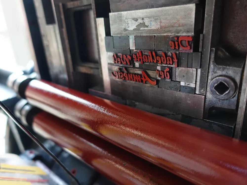 Foto der vom im beim Tiegel vertikal einmontierten Bleisatzform und den zwei Walzen des Farbwerks